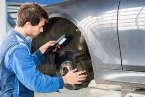 mechanic preforming a brake inspection